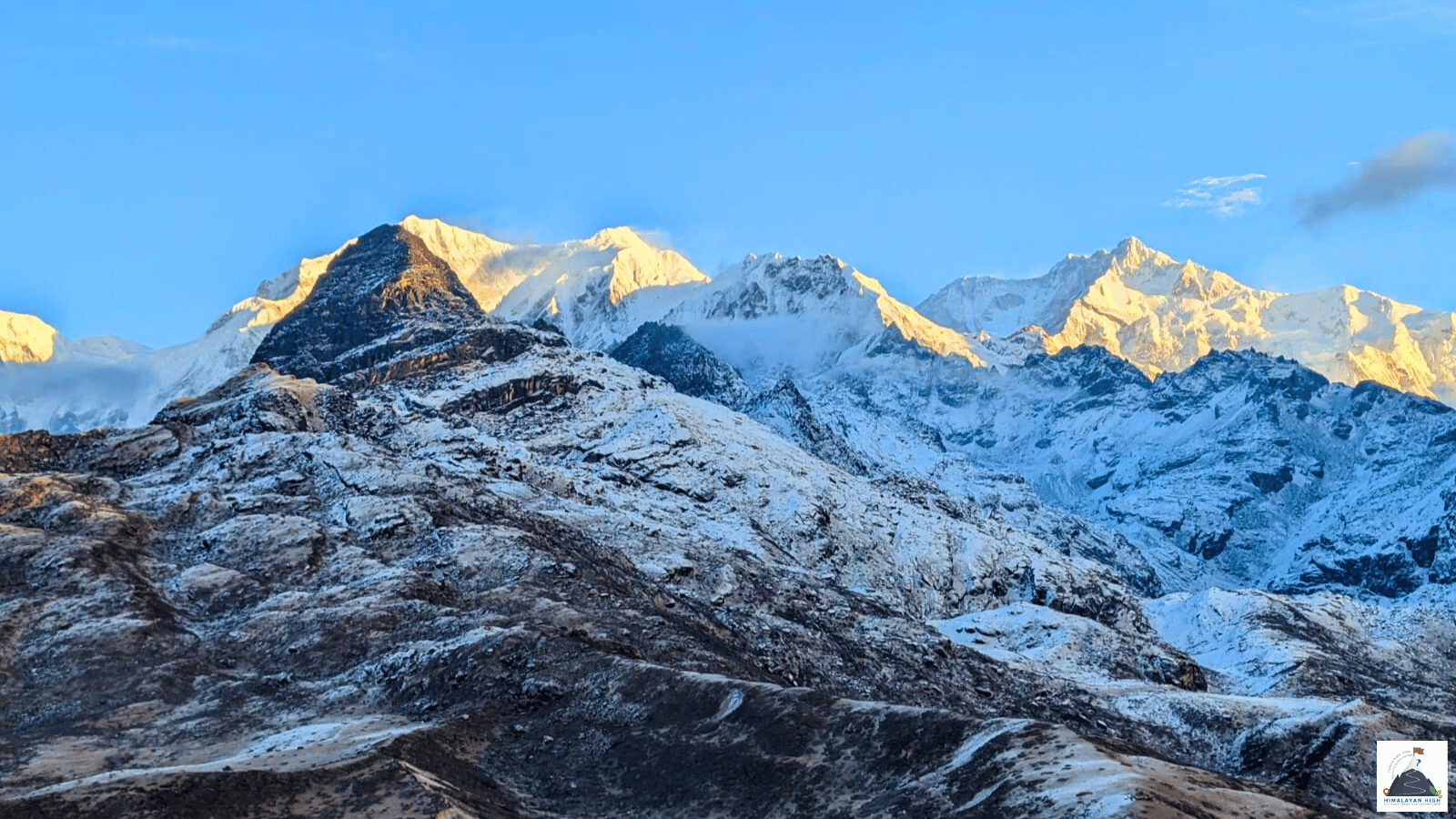 Snow peaks of the Kanchenjunga range turning gold at sunrise above a fresh-snowed ridge near Dzongri