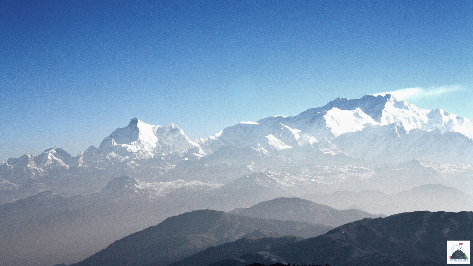The Kanchenjunga range, the Sleeping Buddha, rising above hazy blue ridges, seen from the Singalila ridge